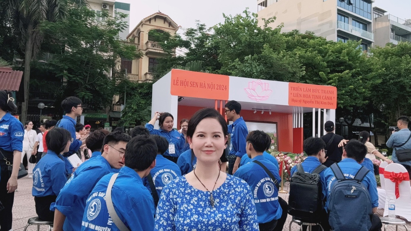 Hoạ sỹ Nguyễn Thị Kim Đức trước khu trưng bày bức tranh của mình