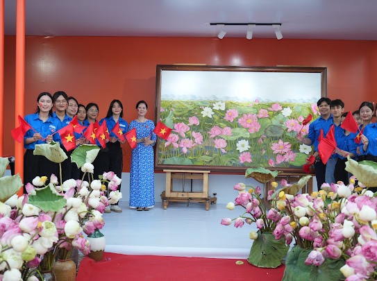 Hoạ sỹ Nguyễn Thị Kim Đức trước khu trưng bày bức tranh của mình 1